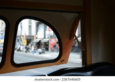 A half-open window of an old bus.