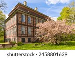 Half-timbered Schönebeck water Castle at Bremen, large blooming cherry tree in front