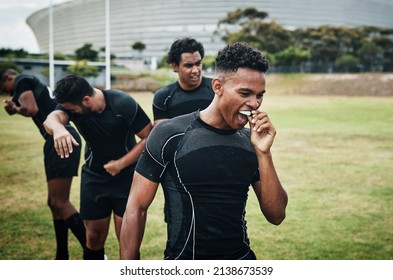 Its half-time. Cropped shot of a handsome young rugby player removing his mouthguard during half-time on the field. - Powered by Shutterstock