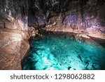 The hall in a big cave. Huge hall of a cave. Big stalactite. The underground lake in a cave. The blue lake in a cave. Blue lake underground