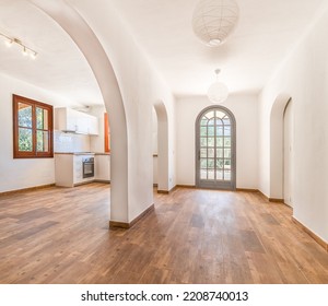 Hall in a country house with wooden floors, white walls and the entrance door at the end - Powered by Shutterstock