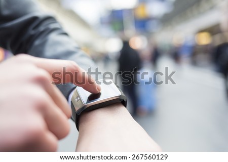 In hall station a man using his smart watch app. Close-up hands