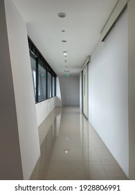 Hall Way In A Building White Color With Green Fire Exit Sign