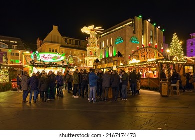 HALLE AN DER SAALE, GERMANY - DECEMBER 17, 2019: Christmas Market On Market Square In Dusk. Many Unknown People Stand Around The Tables Next To The Market Stalls With Food And Christmas Drinks.