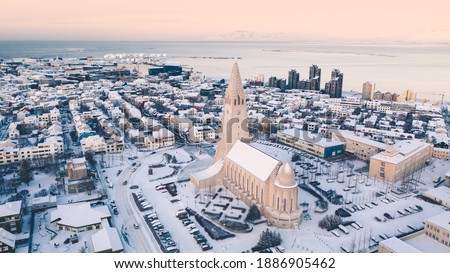 Hallgrimskirkja cathedral church in the center of Reykjavik downtown Iceland. White winter streets covered in snow on the sunset sunrise aerial drone view
