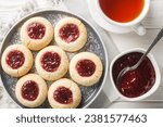 Hallongrottor or Swedish rapsberry caves jam cookies closeup on the plate on the white wooden table. Horizontal top view from above
