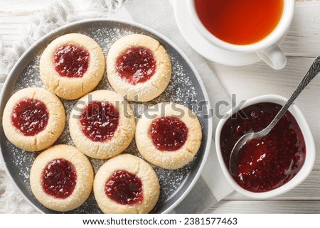Hallongrottor or Swedish rapsberry caves jam cookies closeup on the plate on the white wooden table. Horizontal top view from above
