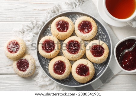 Hallongrottor Swedish Thumbprint Cookies closeup on the plate on the white wooden table. Horizontal top view from above
