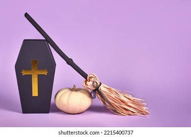 Halloween Arrangement With Coffin Gift Box, Baby Boo Pumpkins And Witch Broom On Purple Background With Copy Space