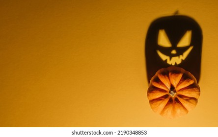 Halloween background concept  Jack O pumpkin angry face shadow  Spooky smiling shadow an orange pumpkin lantern top view close up  Halloween party design
