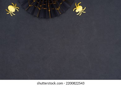 Halloween Background. Scary Halloween Decoration On A Dark Background With Copy Space. Black Paper Fan With Golden Cobweb And Two Shiny Gold Spiders As A Halloween Symbol.