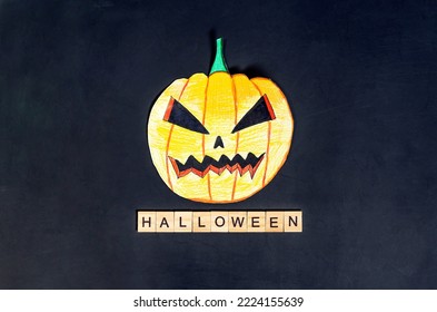 Halloween Background. Halloween Text On Wooden Blocks And Painted Pumpkin On Black Background.