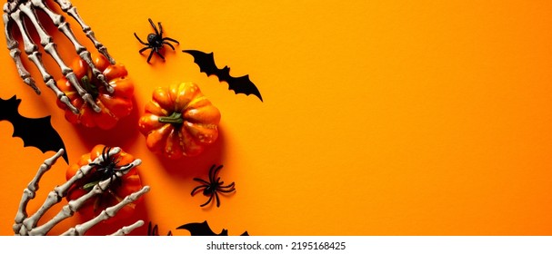 Halloween Banner. Halloween Decorations, Pumpkins, Skeleton Hands, Bats, Spiders On Orange Background. Wide Halloween Banner Mockup, Header, Flyer	