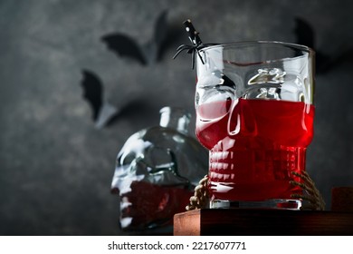 Halloween Bloody Cocktail. Bloody Red Cocktail Glass Goblet For Halloween And Bottle Form Skull On Dark Backgrounds. Halloween Party With Candy Eyes, Bats, Spiders. Dia De Los Muertos. Clous-up.