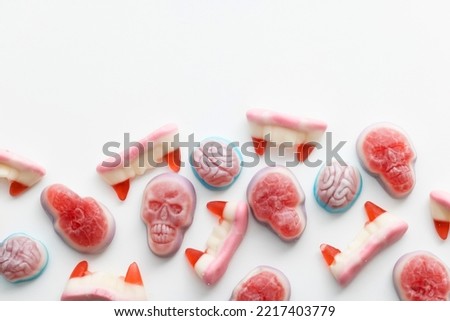 Halloween candy background. Skull, fangs and brain sweets