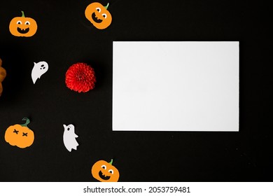 Halloween Card Mockup With Decorations, Pumpkins, Ghosts, Bats On Orange Background. Flat Lay, Top View