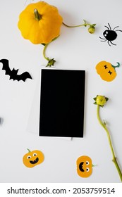 Halloween Card Mockup With Decorations, Pumpkins, Ghosts, Bats On Orange Background. Flat Lay, Top View