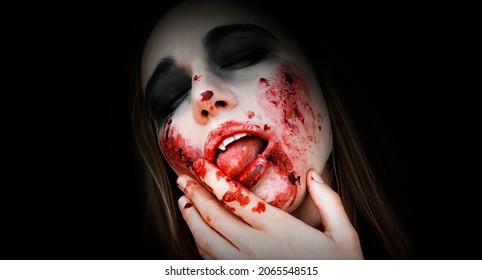 Halloween. Close Up Portrait Bloodthirsty Vampire Woman Attractive Sexy Vampire Woman With Sharp Teeth, Fangs, Blood Drops.Black Background, Copy Space. 