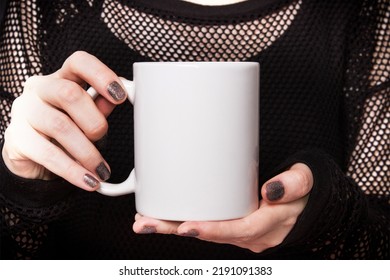 Halloween coffee mug in girl's hands wearing black dress. Mockup for product presentation - Shutterstock ID 2191091383