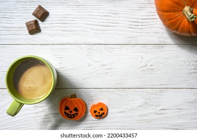 Halloween And Coffee Theme, Orange Pumpkin, Sweets And Cup On White Table, Top View. Holiday Food On Wood Planks Background With Space, Flat Lay. Party, Season, October, Hallowen And Frame Concept.