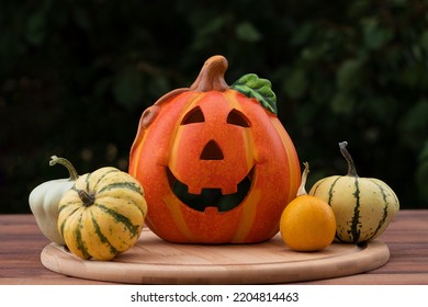 Halloween composition with Jack-o-latern and decorative pumpkins against blurred background. Selective focus