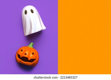 Halloween concept background. Funny halloween pumpkin and halloween ghost with copy space over purple and orange background