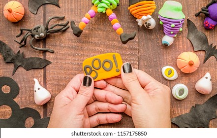 Halloween Concept. Female Hands With Black Nails Making Halloween Cupcake Craft Top View