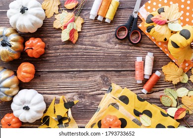 Halloween Concept. Top View Of Halloween Decorations And Sewing Items Making Textile Pumpkin Craft With Copy Space Over Wooden Background