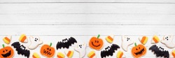 Halloween Cookie Bottom Border. Top View On A White Wood Banner Background With Copy Space. Ghosts, Bats, Jack O Lanterns And Candy Corn.