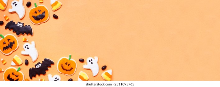 Halloween cookie corner border. Above view on an orange banner background with copy space. Ghosts, bats, jack o lanterns and candy corn. - Powered by Shutterstock