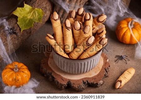 Halloween cookies witch`s fingers with chocolate and almond nuts. Delicious and scary dessert for treats.