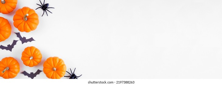 Halloween corner border of orange pumpkins with black bats and spiders. Top view over a white banner background. Copy space. - Shutterstock ID 2197388263