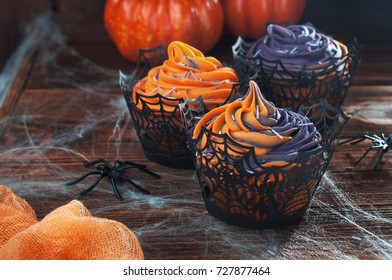 Halloween Cupcakes With Whipped Cream And Sprinkles On Rustic Wooden Table Covered With Spiderweb And Spiders; Selective Focus.