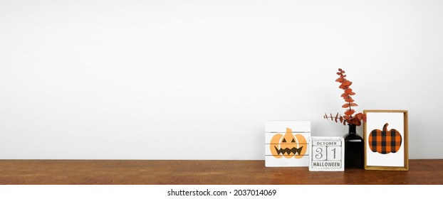 Halloween Decor On A Wood Shelf. Shabby Chic Wood Signs, Calendar And Orange Branches Against A White Wall Banner. Copy Space.