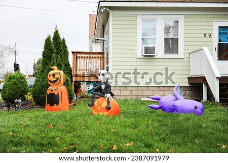 Halloween decor outside a house, featuring pumpkins, ghosts, and eerie lighting, creating a festive and haunting atmosphere