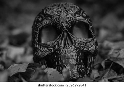 Halloween decor, plastic skull with Mexican Day of the Dead pattern among yellow autumn leaves. Autumn holiday Halloween. Black and white horizontal close-up photo. - Powered by Shutterstock