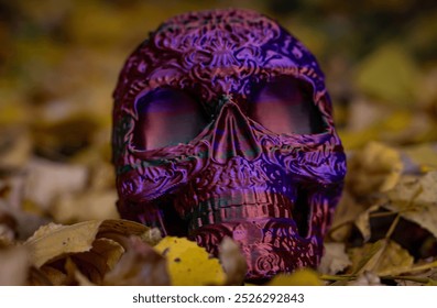 Halloween decor, plastic skull with Mexican Day of the Dead pattern among yellow autumn leaves. Autumn holiday Halloween. Color horizontal close-up photo. - Powered by Shutterstock