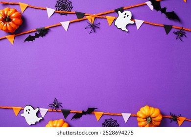 Halloween decorations with pumpkins, ghosts, spiders, and bunting on a purple background - Powered by Shutterstock