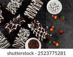 Halloween dessert. Chocolate brownie decorated with chocolate icing in the shape of a mummy and with a spider on a web. Top view, copy space