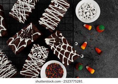 Halloween dessert. Chocolate brownie decorated with chocolate icing in the shape of a mummy and with a spider on a web. Top view, copy space - Powered by Shutterstock