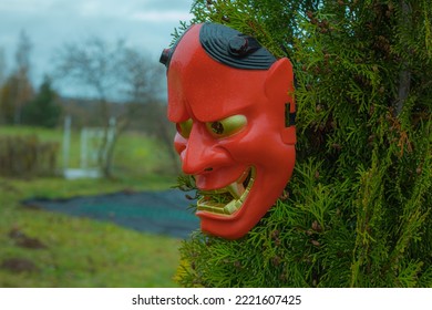 Halloween Devil Mask On A Bush Near The House In The Garden. A Festive Event. Zina, Latvia - 02.11.2022