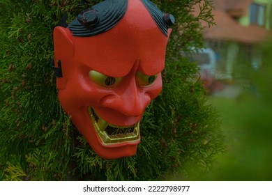 Halloween Devil Mask On A Bush Near The House In The Garden. A Festive Event. Zina, Latvia - 02.11.2022