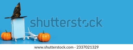Halloween flight sale, airplane tickets, international flights, travel and trips, plane and luggage in a halloween hat with pumpkins on a blue background with copy space,holidays and vacations