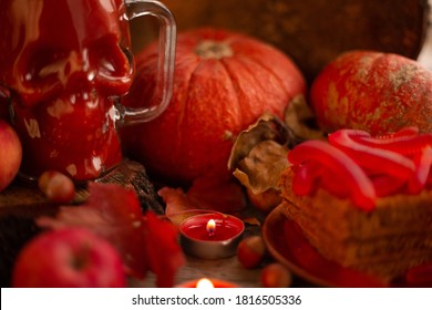 Halloween Food Still Life Abstract Background With Pumpkins, Apples, Cake, Gummy Worms, Skull Red Drink And Candles