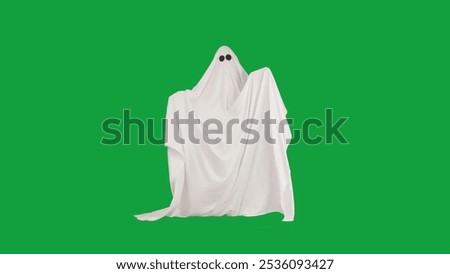 Halloween ghost in white sheet posing moving hands at camera isolated on chroma key green screen background, full length. Spooky concept.