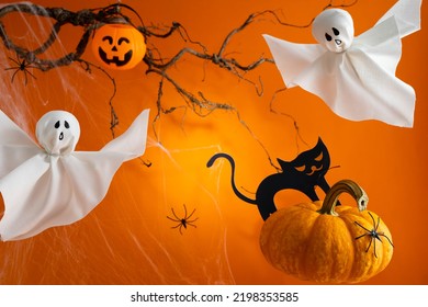 Halloween ghosts, pumpkins and black cat on orange background. Happy Halloween holiday concept. Handmade decoration for festival party. - Shutterstock ID 2198353585