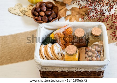 Halloween gif box with spices, biscuits, nuts and pumpkin. Eco friendly gift basket for holiday, top view, flat lay. 