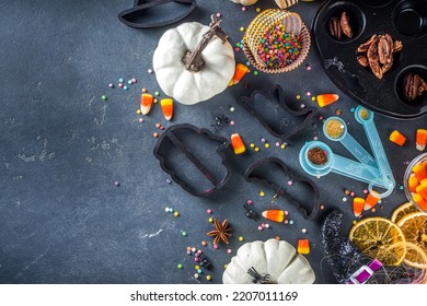 Halloween Gingerbread Cookies Cooking Background. Autumn Holiday Baking Concept, Ingredients, Spices, Halloween Symbol Cookie Cutters - Pumpkin, Ghost, Bat, Witch Hat, Top View Black Table Copy Space