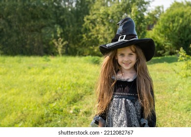 Halloween girl going to collect candy. Trick-or-treating. Guising. Jack-o-lantern. Child in carnival costume witch outdoors. Celebrate halloween. Girl in forest smiling and holding basket of sweets - Shutterstock ID 2212082767