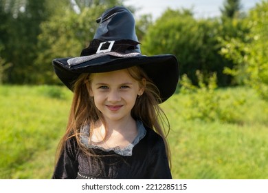 Halloween girl going to collect candy. Trick-or-treating. Guising. Jack-o-lantern. Child in carnival costume witch outdoors. Celebrate halloween. Girl in forest smiling and holding basket of sweets. - Shutterstock ID 2212285115